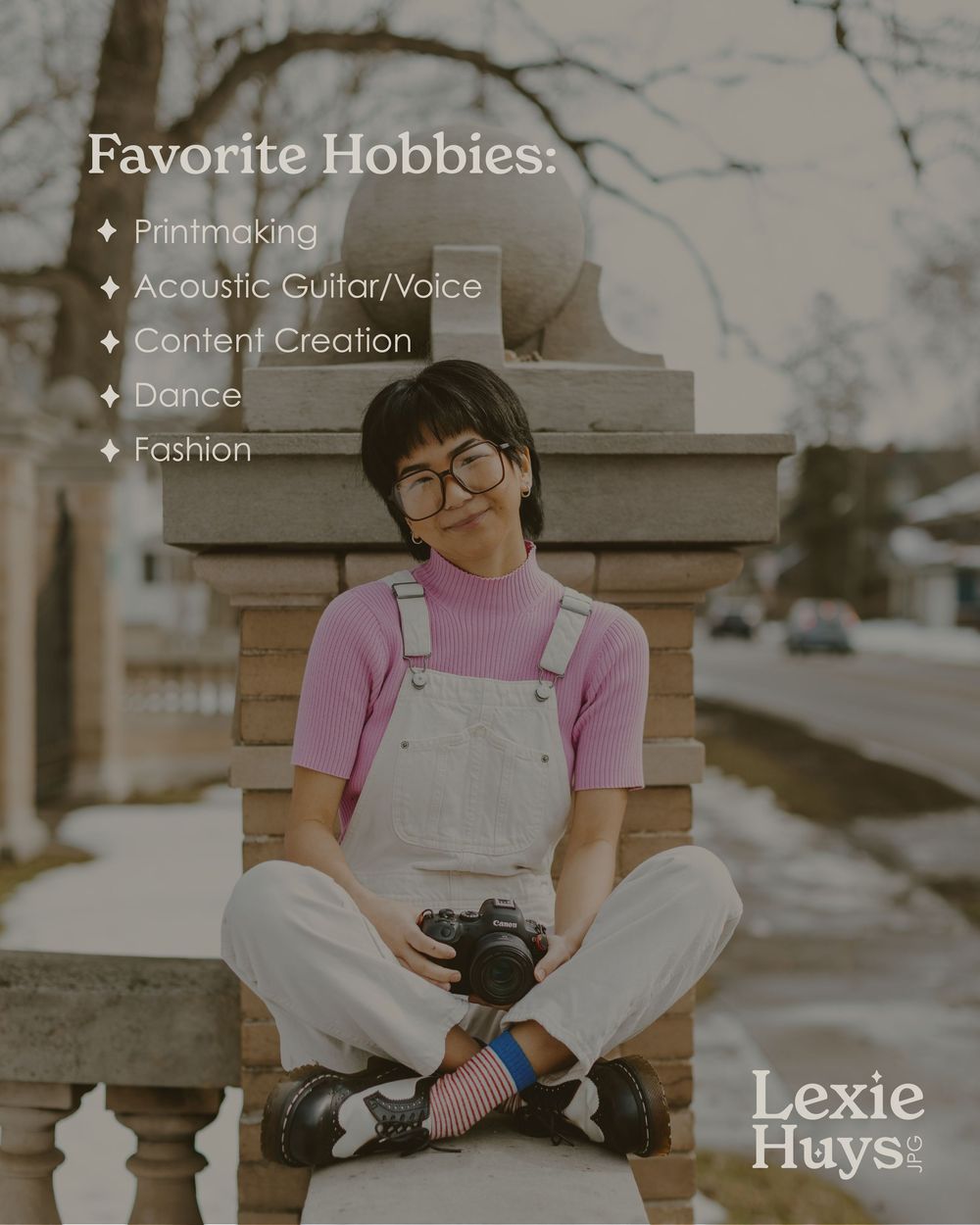 Lexie Huys sits cross-legged on a stone wall holding a camera, showcasing her hobbies including printmaking and dance.