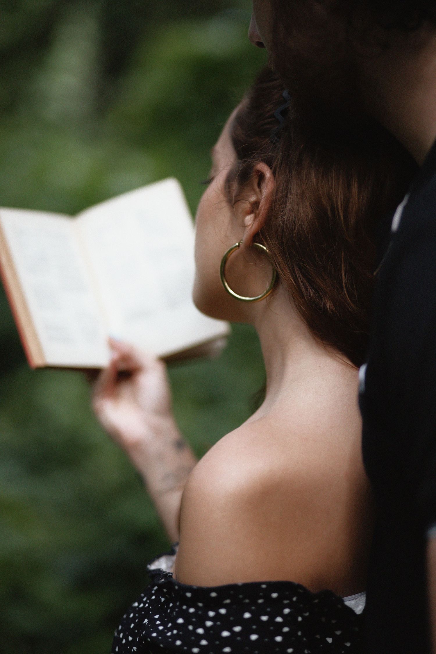 Couple reading book at Kendall Indian Hammocks Park Miami during engagement couples session.