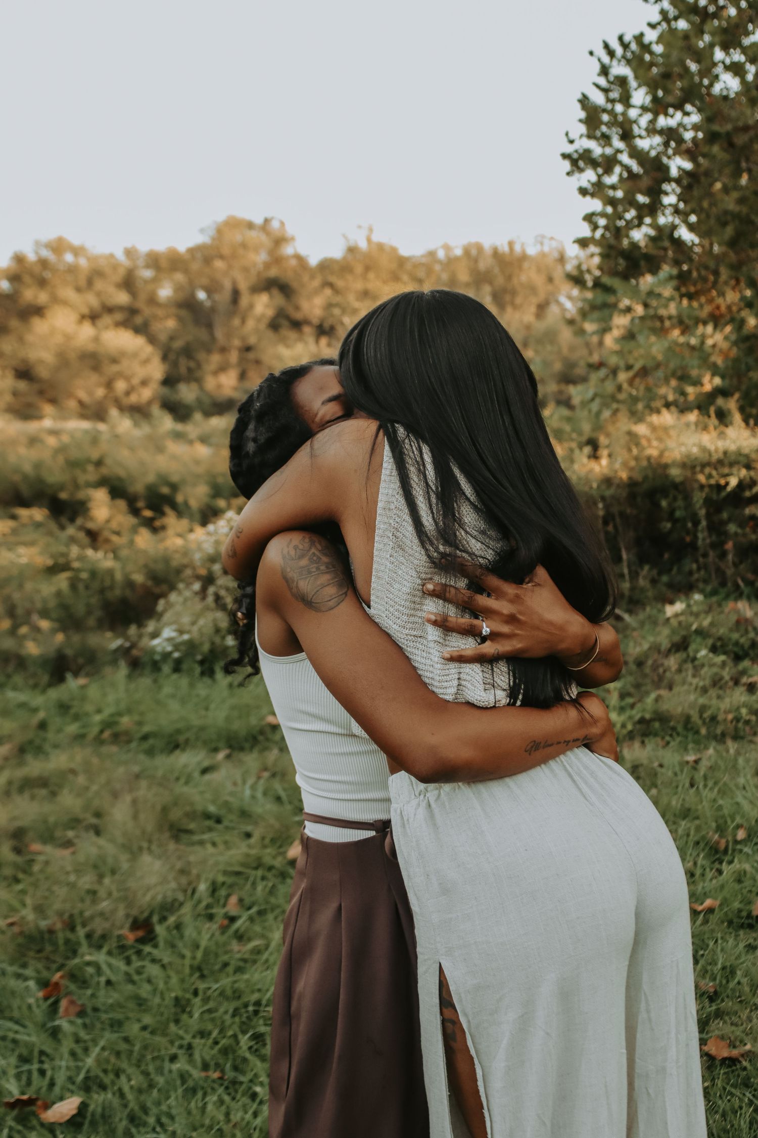 A joyful couple dances on a wooden deck surrounded by greenery.