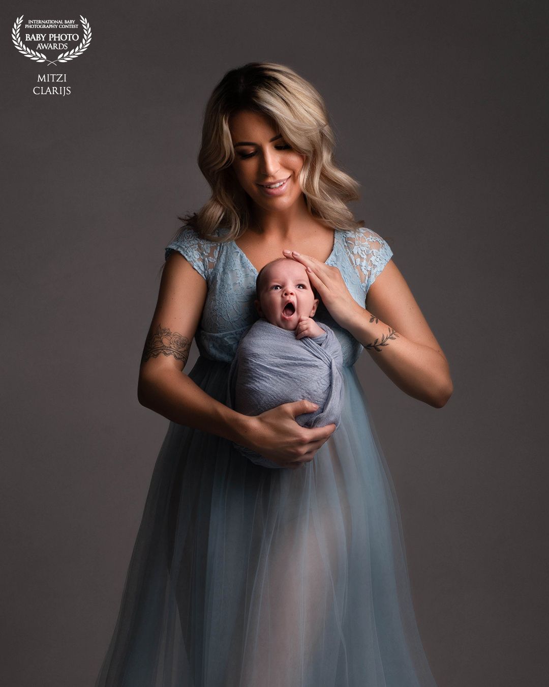 Award winnende foto internationale wedstrijd van moeder met pasgeboren baby in wrap tijdens newbornshoot in studio in Goes, Zeeland