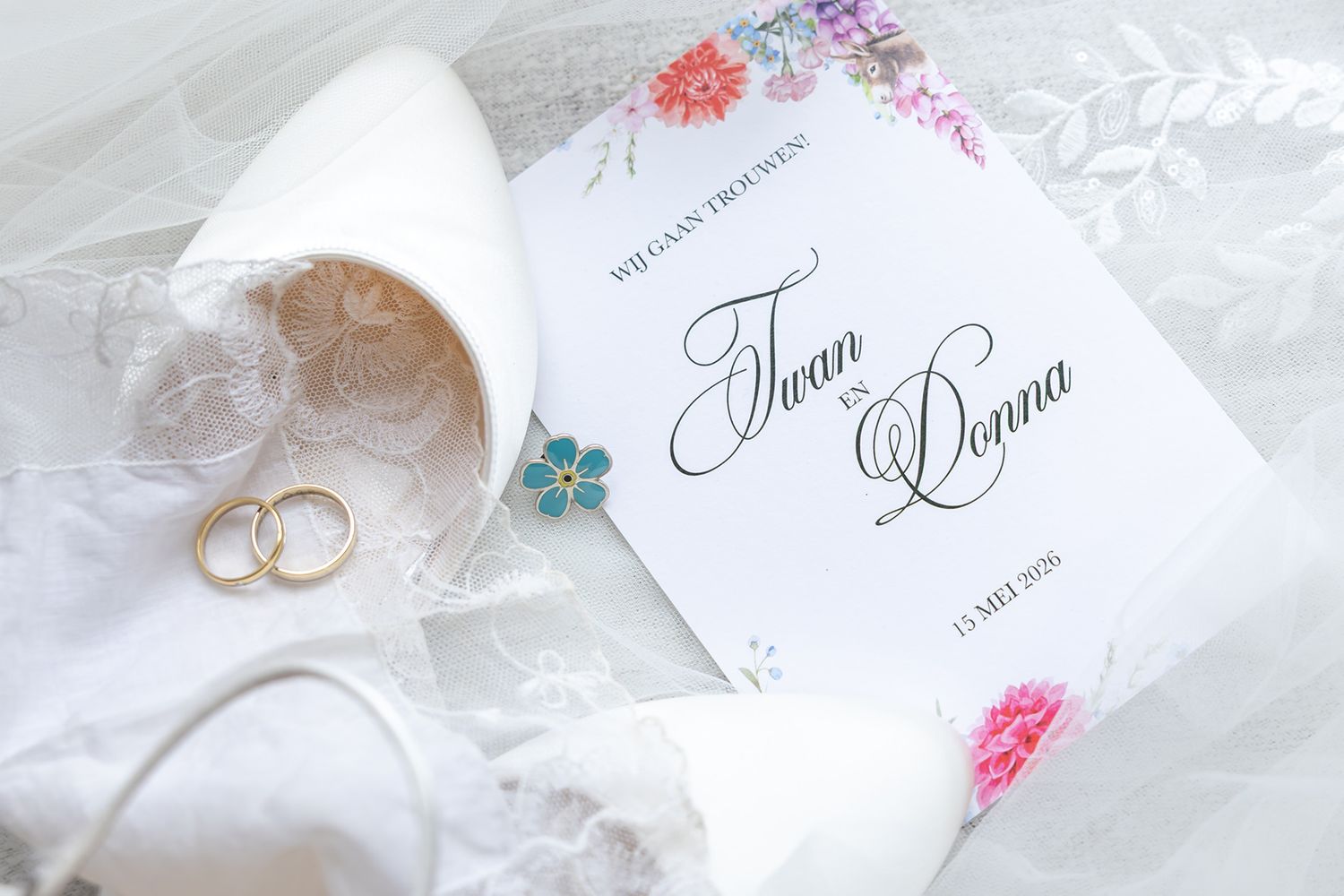 Flatlay met bruidsschoenen, trouwringen en kanten zakdoekje op de sluier van Donna, tijdens haar bruiloft bij Krelis in Uitgeest