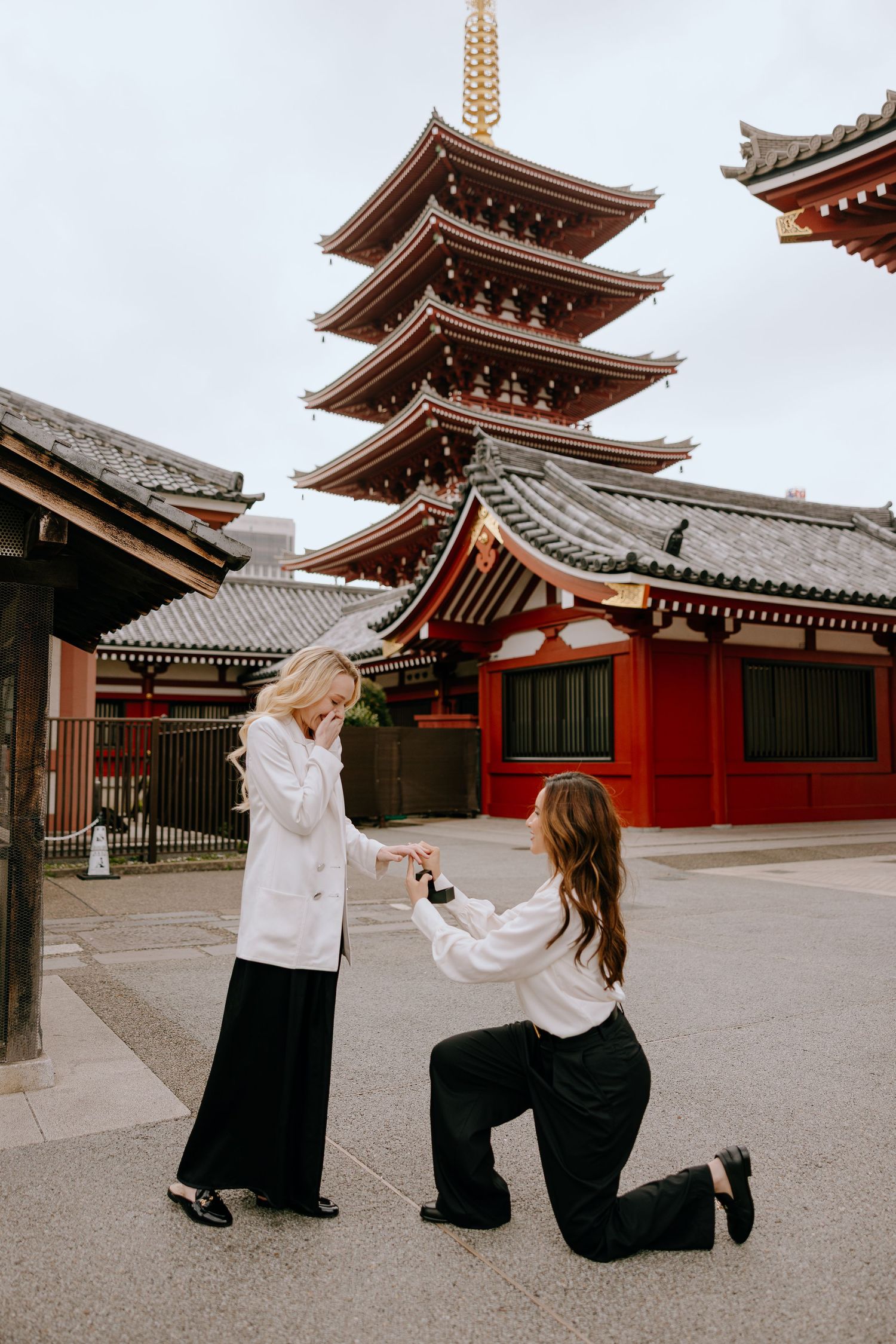Two women in a same-sex proposal at Senso-ji Temple pagoda in Tokyo, Japan.