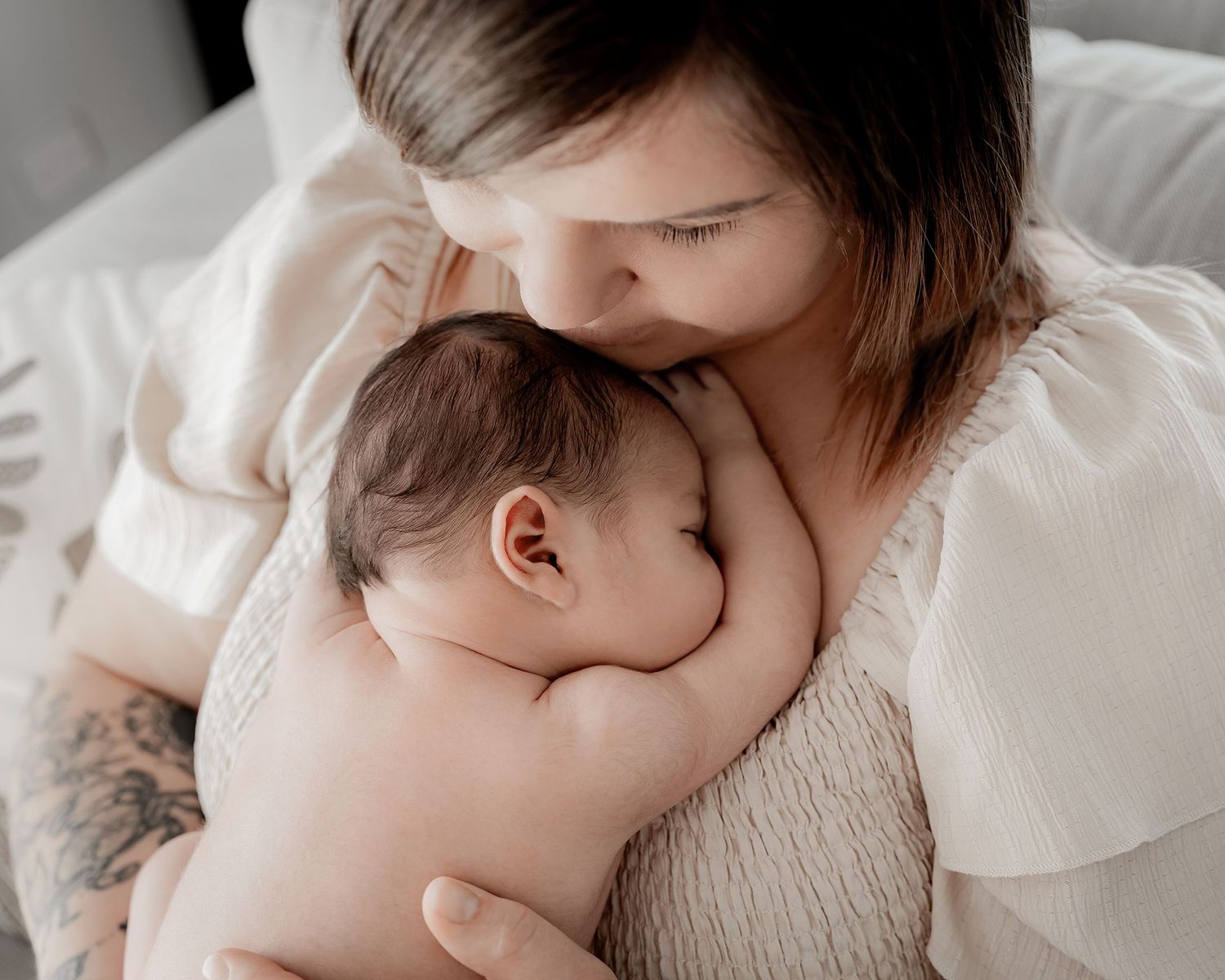 Mother cuddling newborn baby during photography session