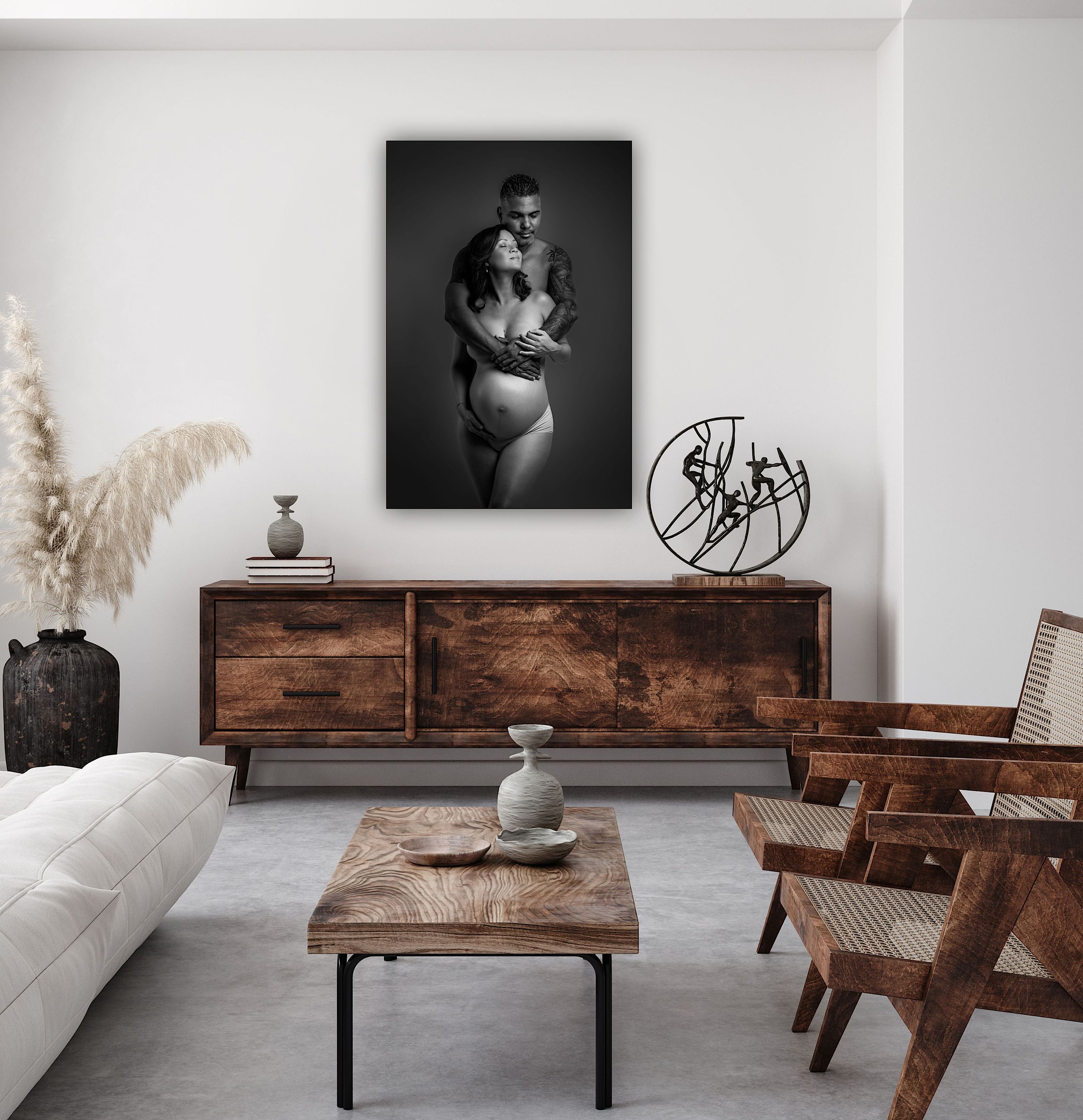Black and white fine art photo print of a couple embracing, displayed on wall above rustic wood sideboard in modern living room.
