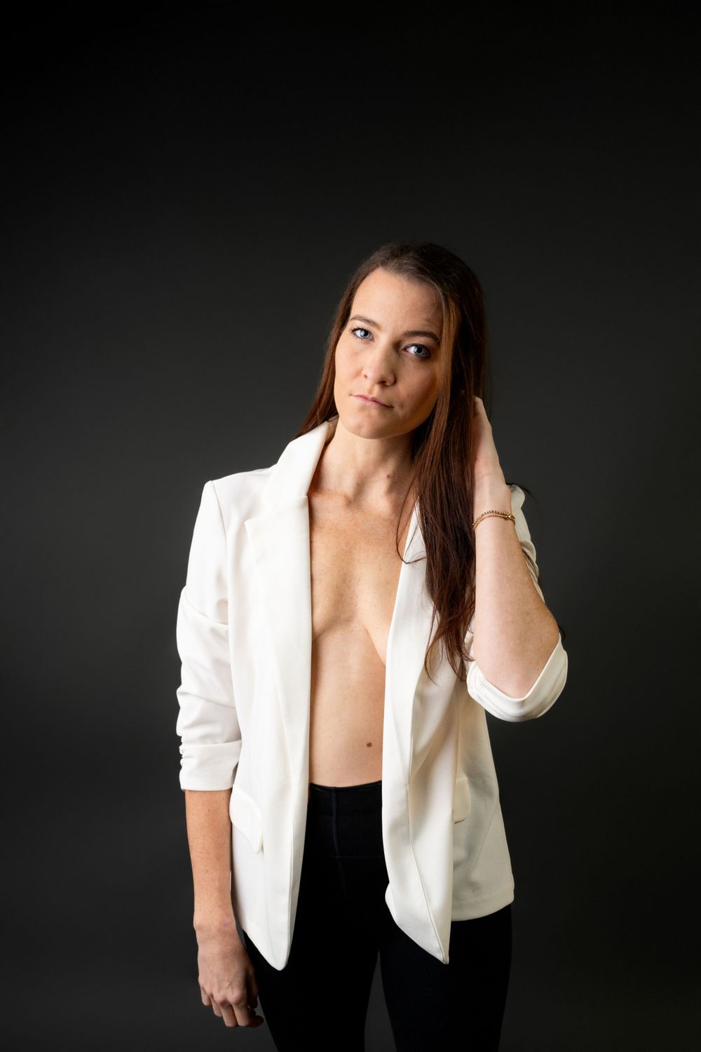 Fashion portraits featuring a white blazer and dark background composition.
