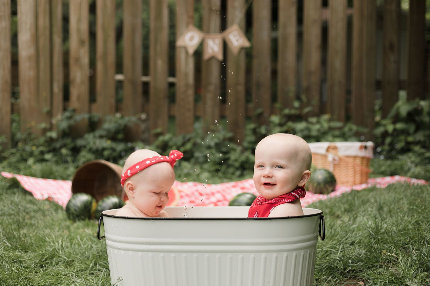 Two small children sitting in galvanized metal tub during outdoor photo session.