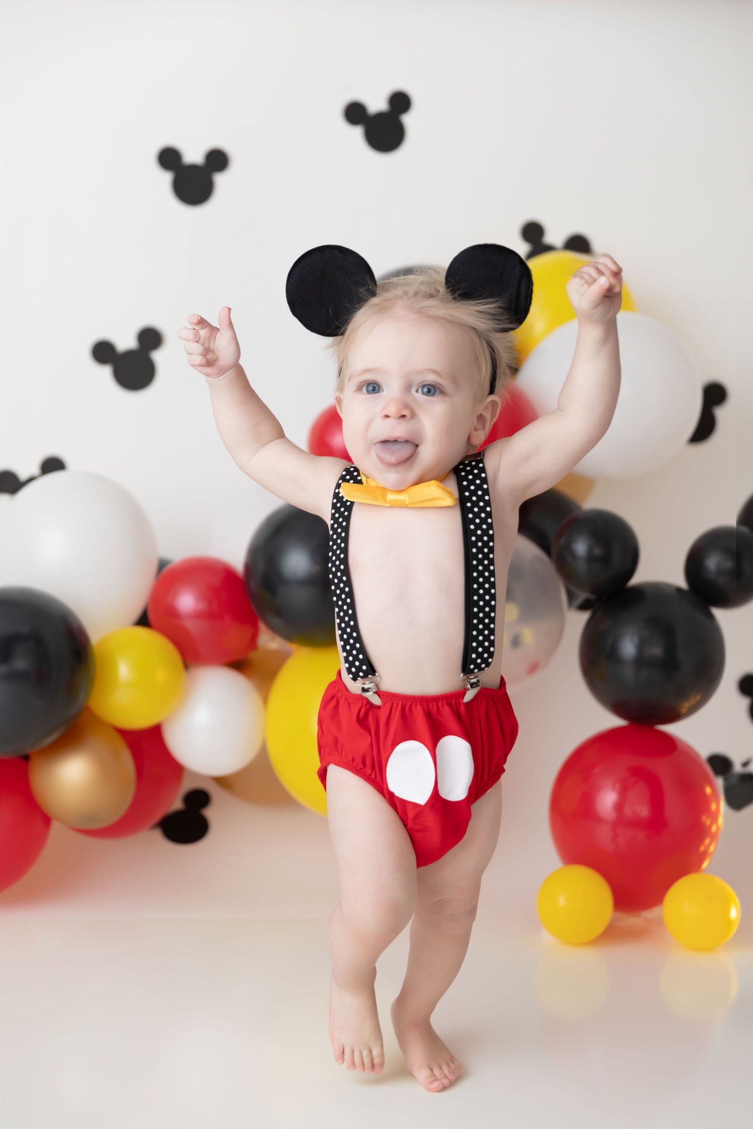 Mickey Mouse themed birthday party setup with balloons and decorations featuring red, black, yellow and white colors.