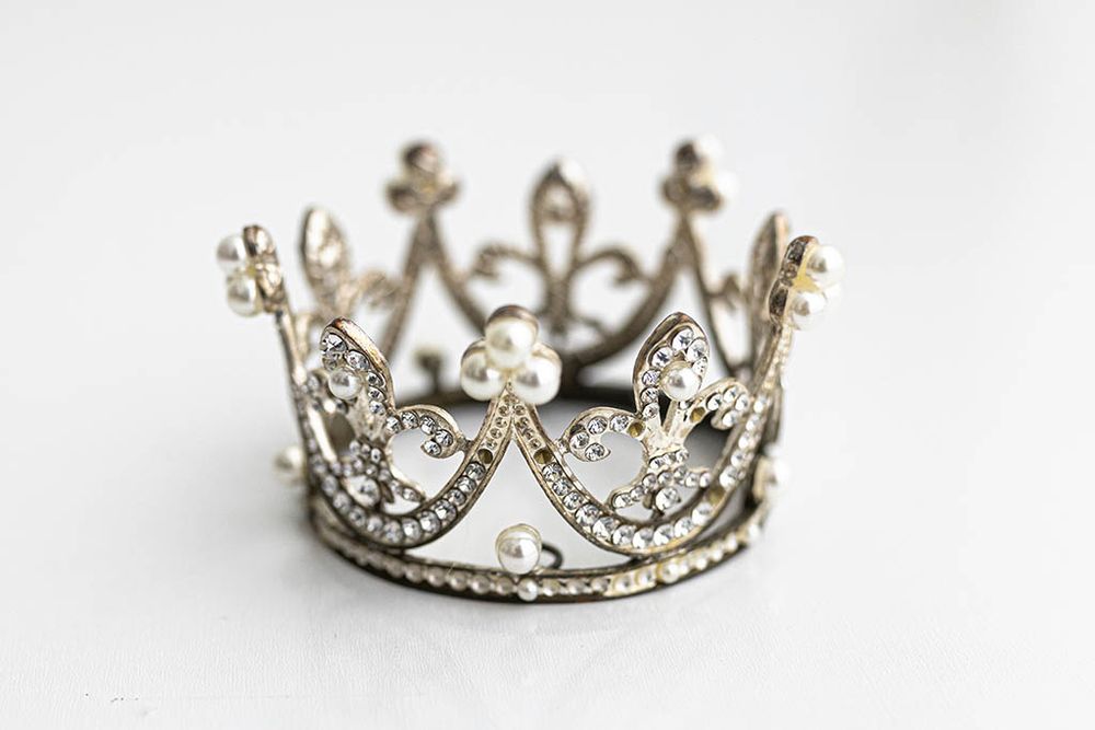 Ornate silver mini crown with rhinestone and pearl embellishments for baby photos.