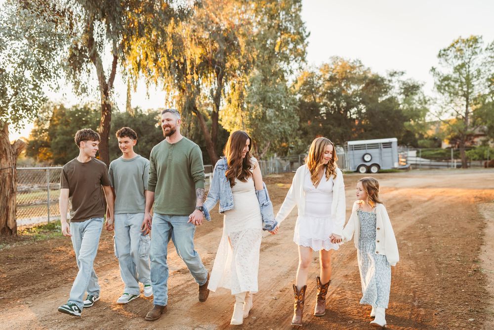 Family of six walking hand-in-hand on a dirt path for family photos with heidi grace photography