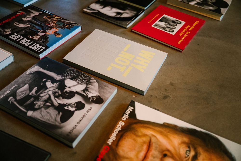 Collection of photography and music books spread on a table, including black and white photo books and colorful covers.