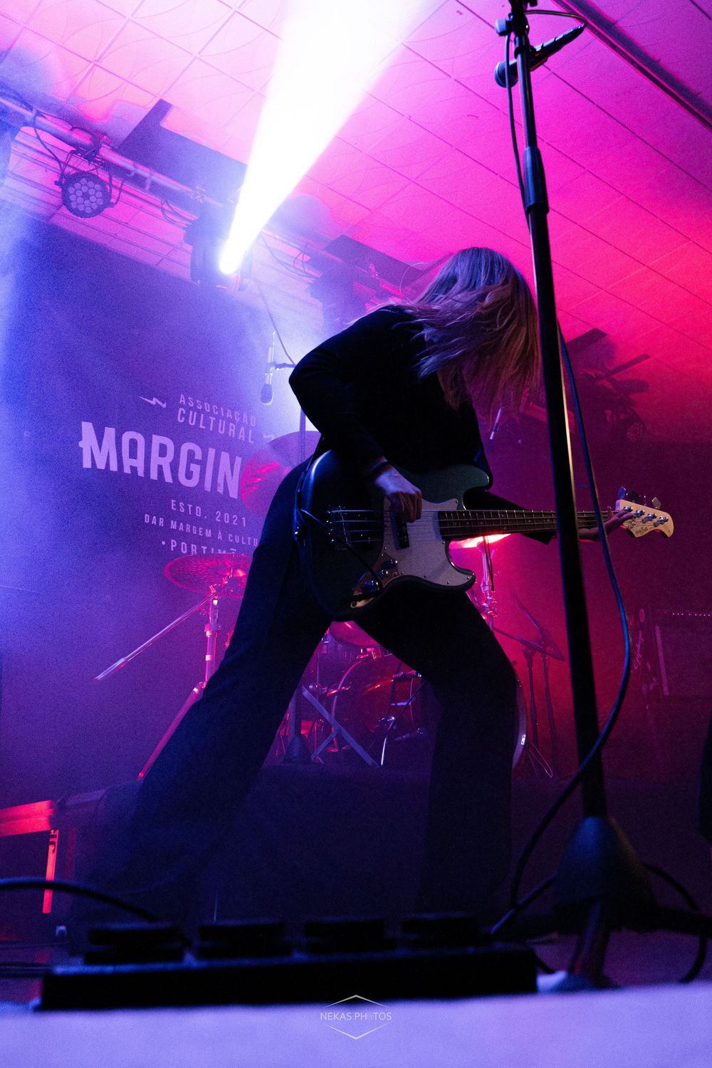 Guitarist performing on stage at Margin cultural venue, bathed in purple and pink lights with dramatic fog effects.