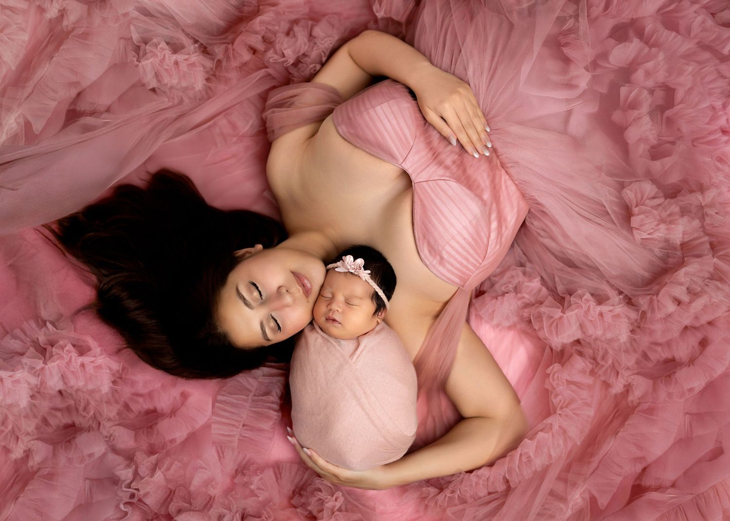Newborn photography Covina CA mother holding baby in soft pink studio session by Ester Nguyen Photography