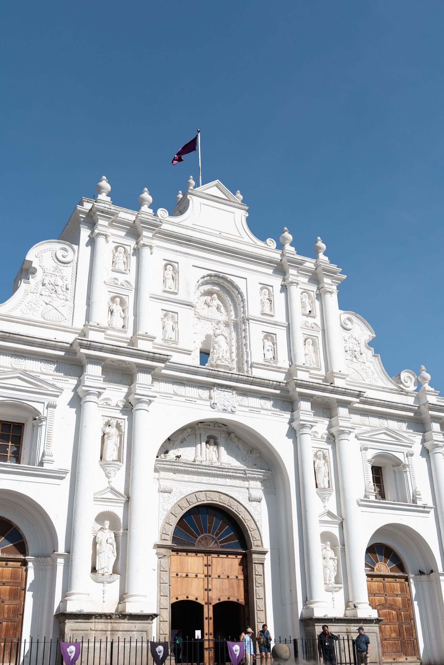 Historic white colonial church facade illuminated at night with ornate architectural details and arched entryways.