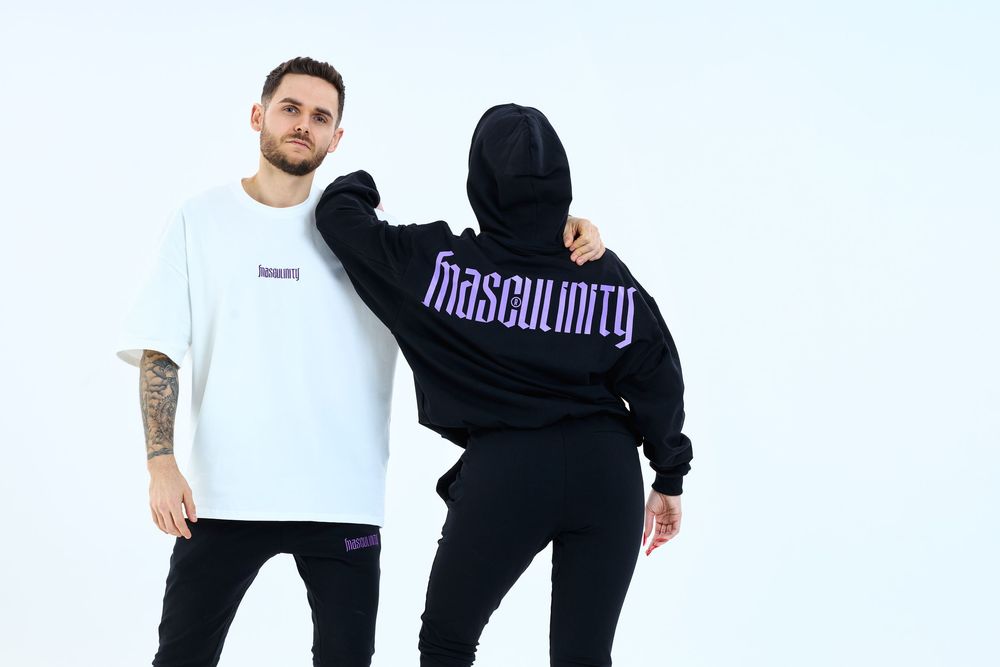 Two models wearing Masculinity brand streetwear, one in white tee and one in black hoodie, against white background.