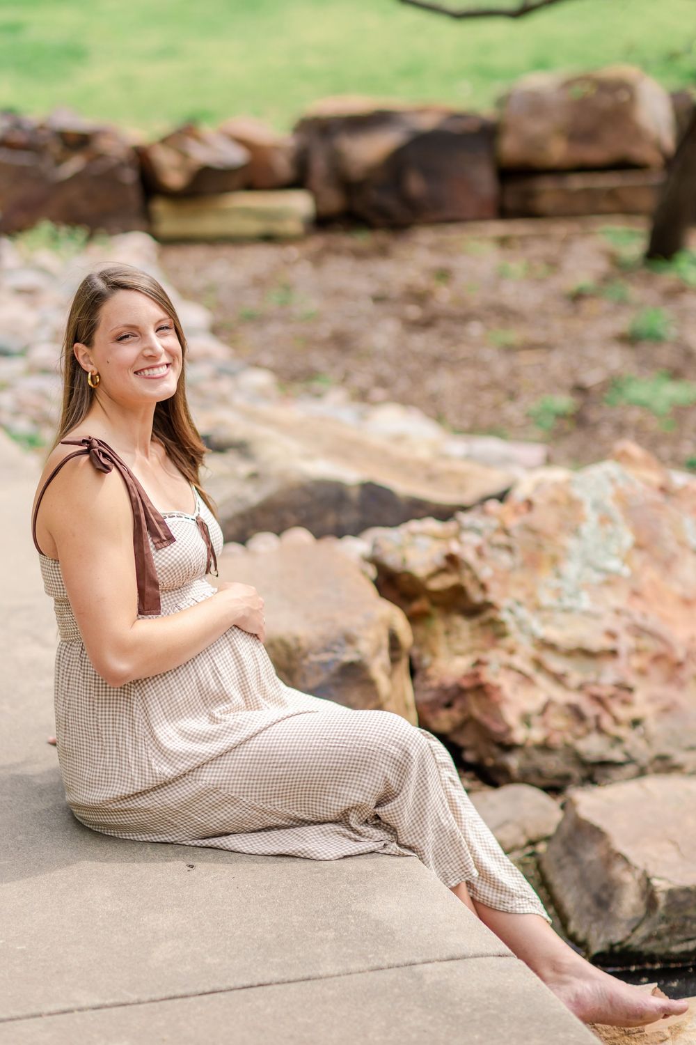 Hands resting on growing belly during a spring maternity session in Wichita