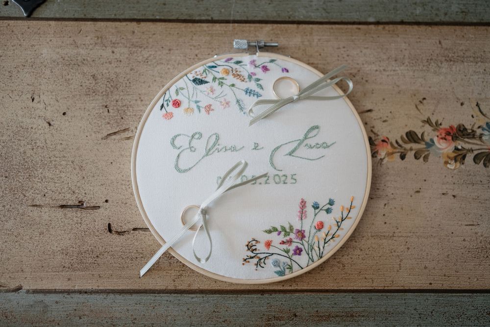 Custom embroidered wedding ring bearer hoop with floral design reading Elisa e Luca 2025.