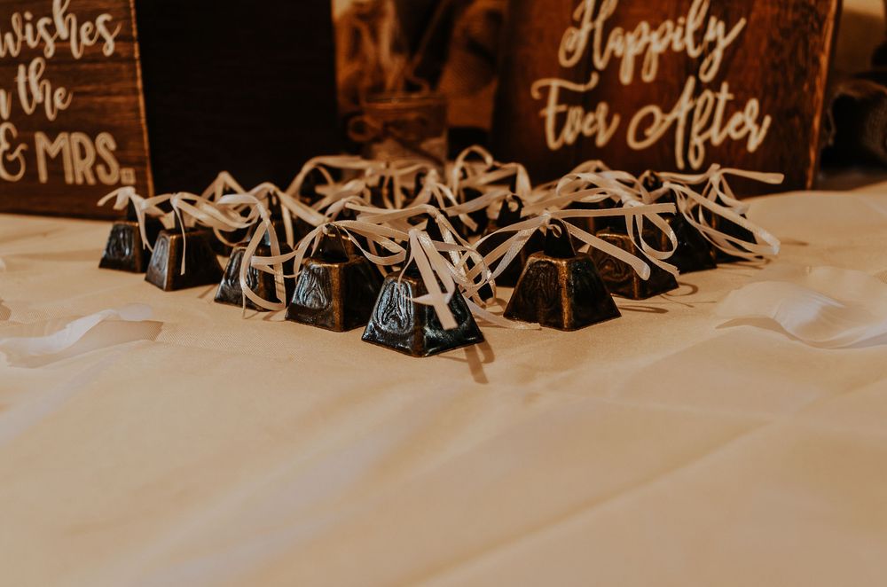 Wedding favor table with pyramid-shaped chocolate boxes tied with twine, displayed near a Happily Ever After sign.