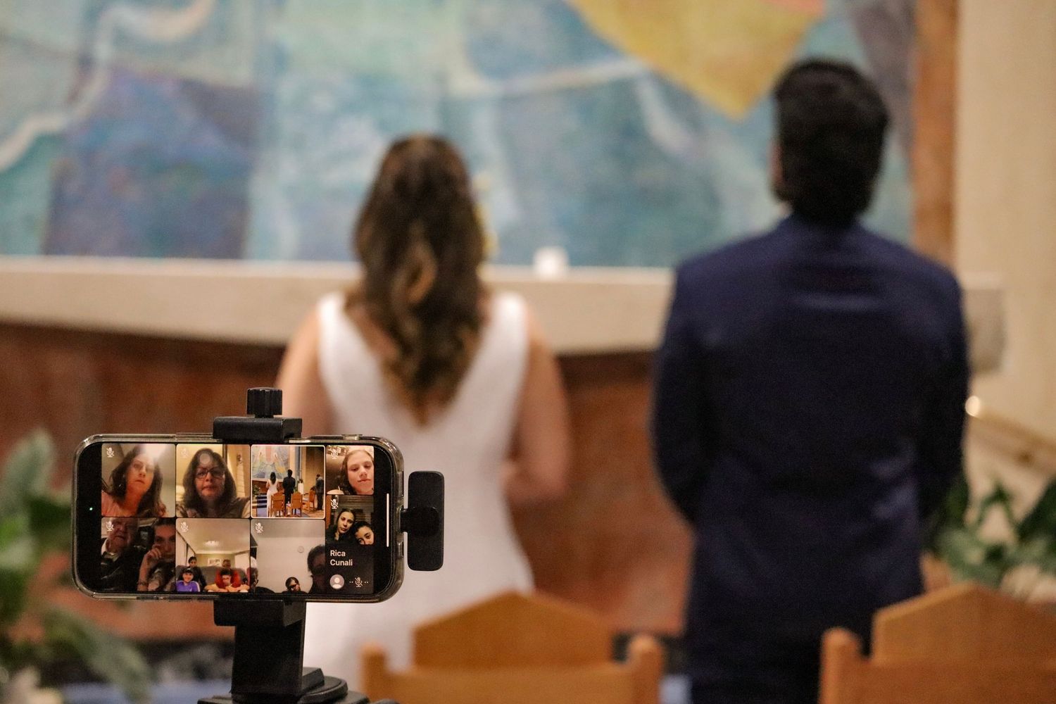 Church wedding ceremony with mobile phone recording in background.