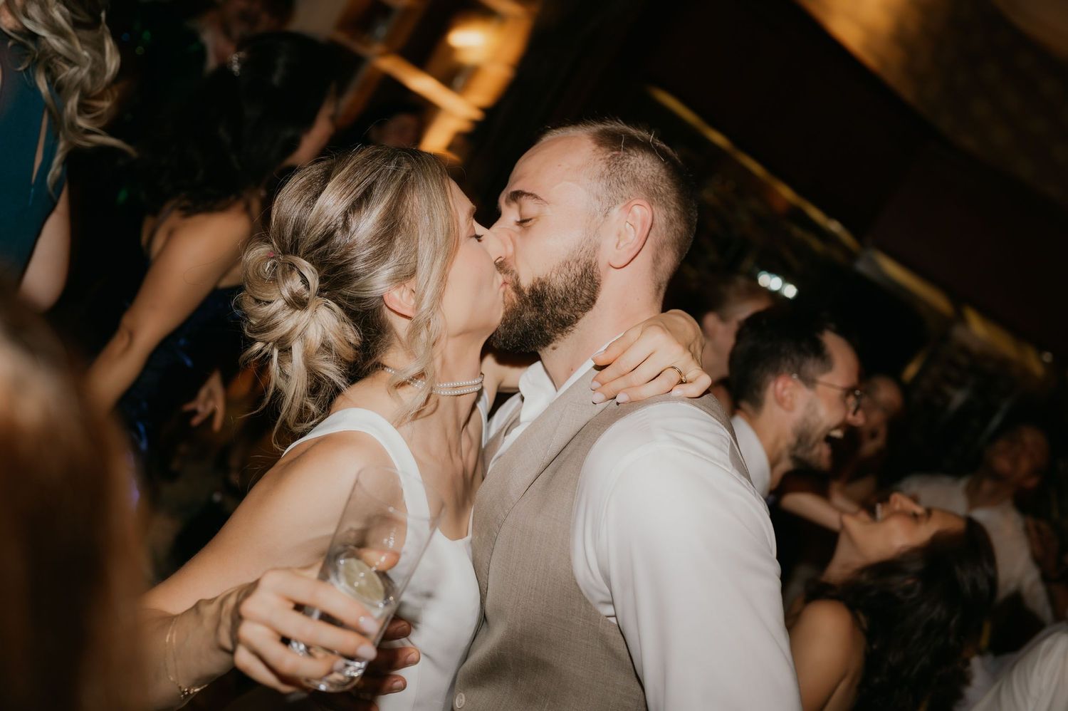 Bride and groom sharing a romantic kiss on the dance floor at their wedding reception.