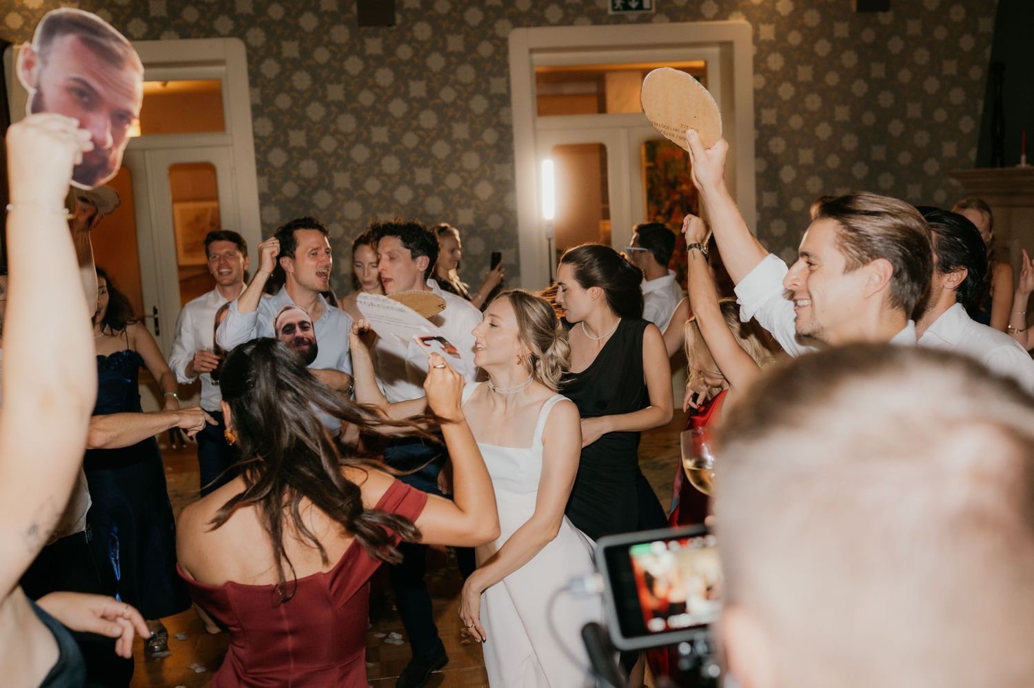 Joyful wedding reception dance floor with bride and guests celebrating together.