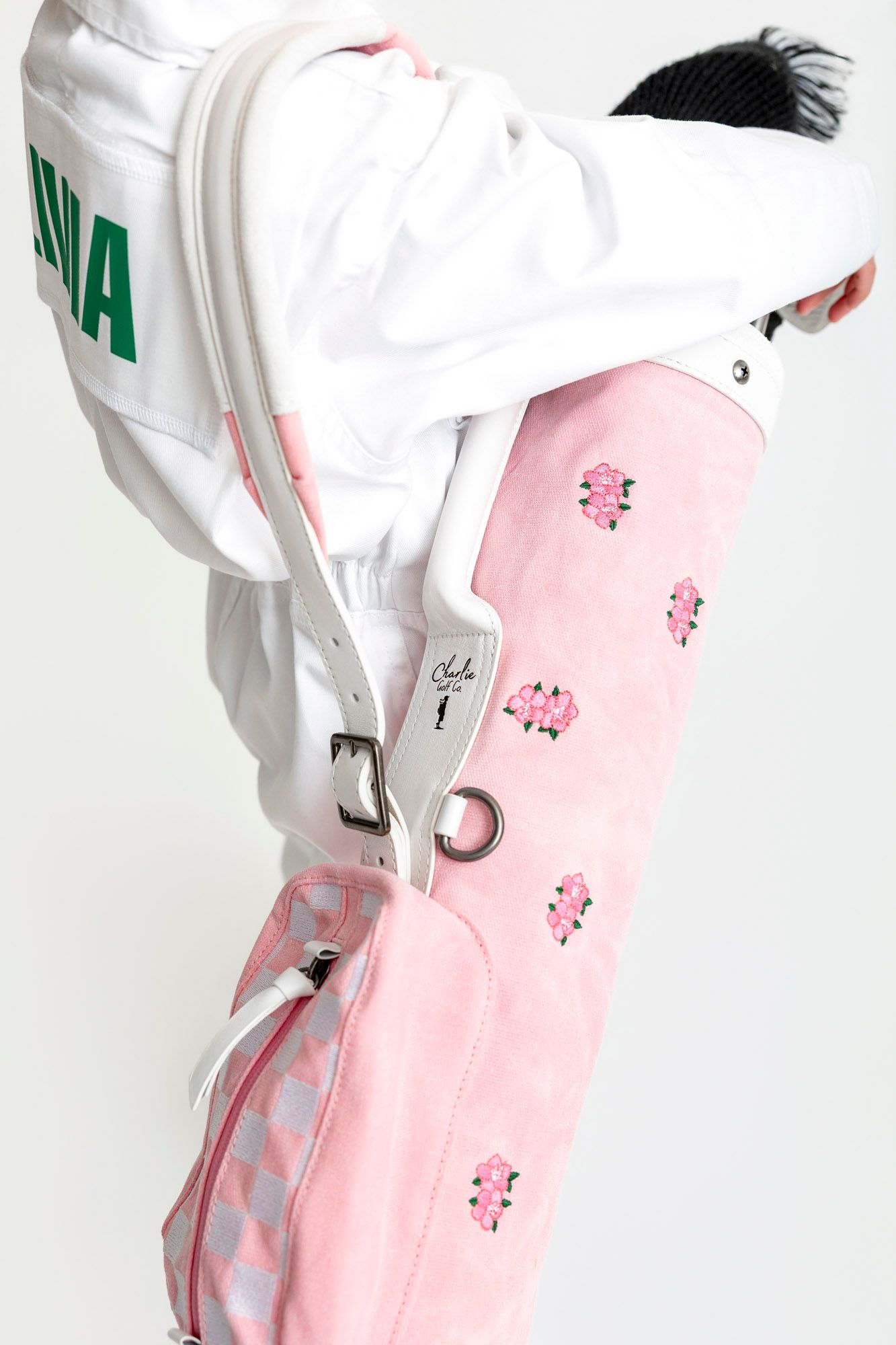Close-up view of a white medical glove holding a pink pill bottle against a white background.