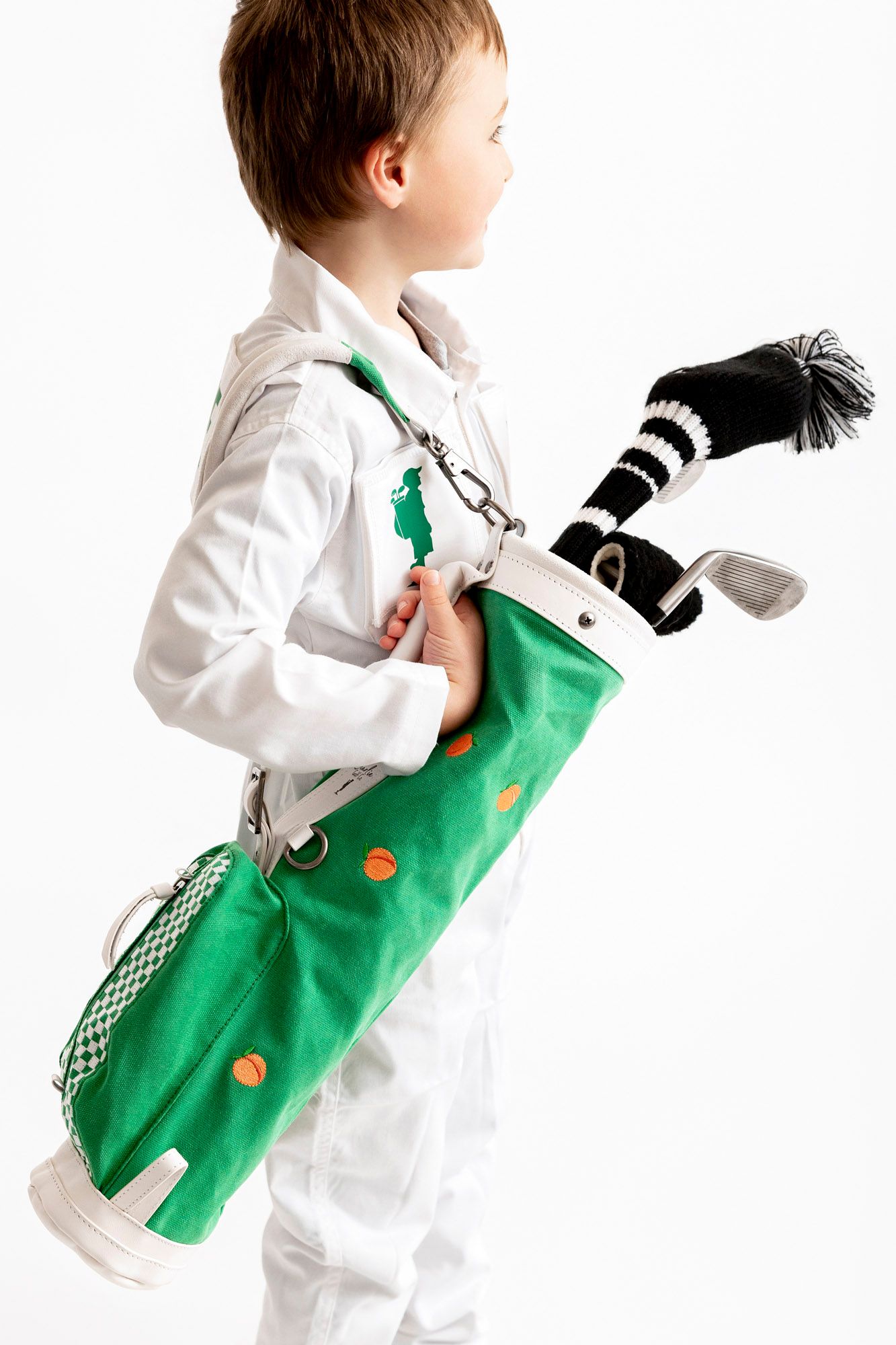 Child in white clothing carries a green shopping bag while walking, shown in multiple sequential poses.