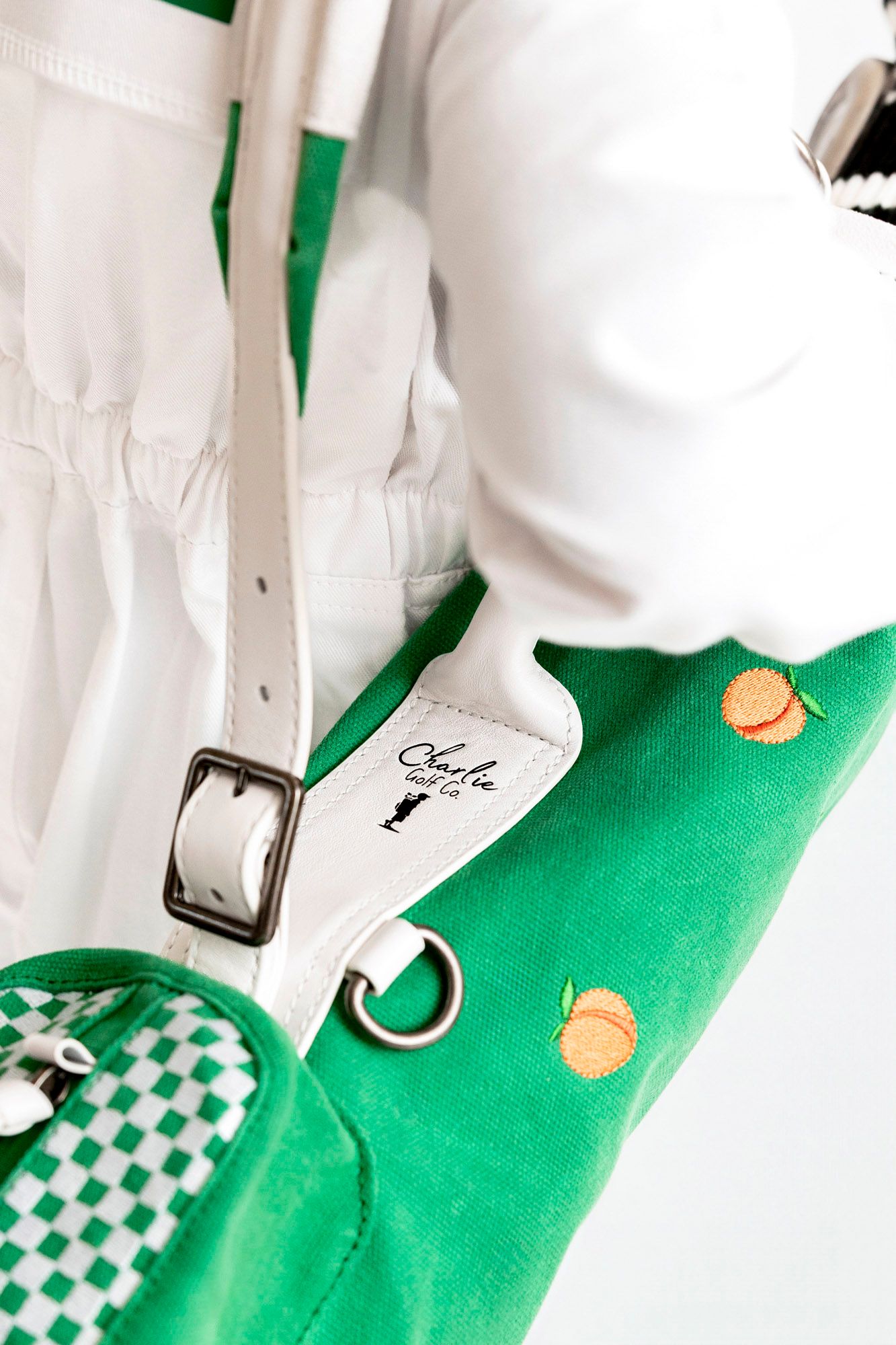 White sneakers with green accents and checkered pattern details rest against a bright green background.