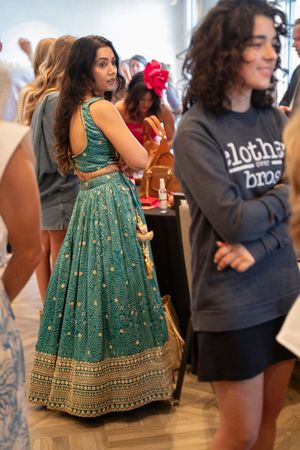 A guest wearing a traditional Indian dress dancing behind the scenes at the 2026 Azalea Festival Spring Fashion Show
