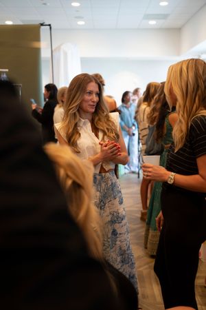 Guest mingling at a social gathering in a bright indoor venue behind the scenes at the 2026 Azalea Festival Spring Fashion Show