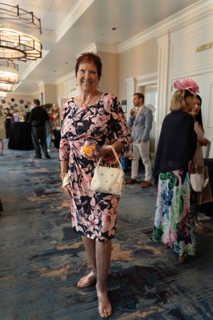 Guest gather in the backstage hallway with floral carpeting at the 2026 North Carolina Azalea Festival Spring Fashion Show