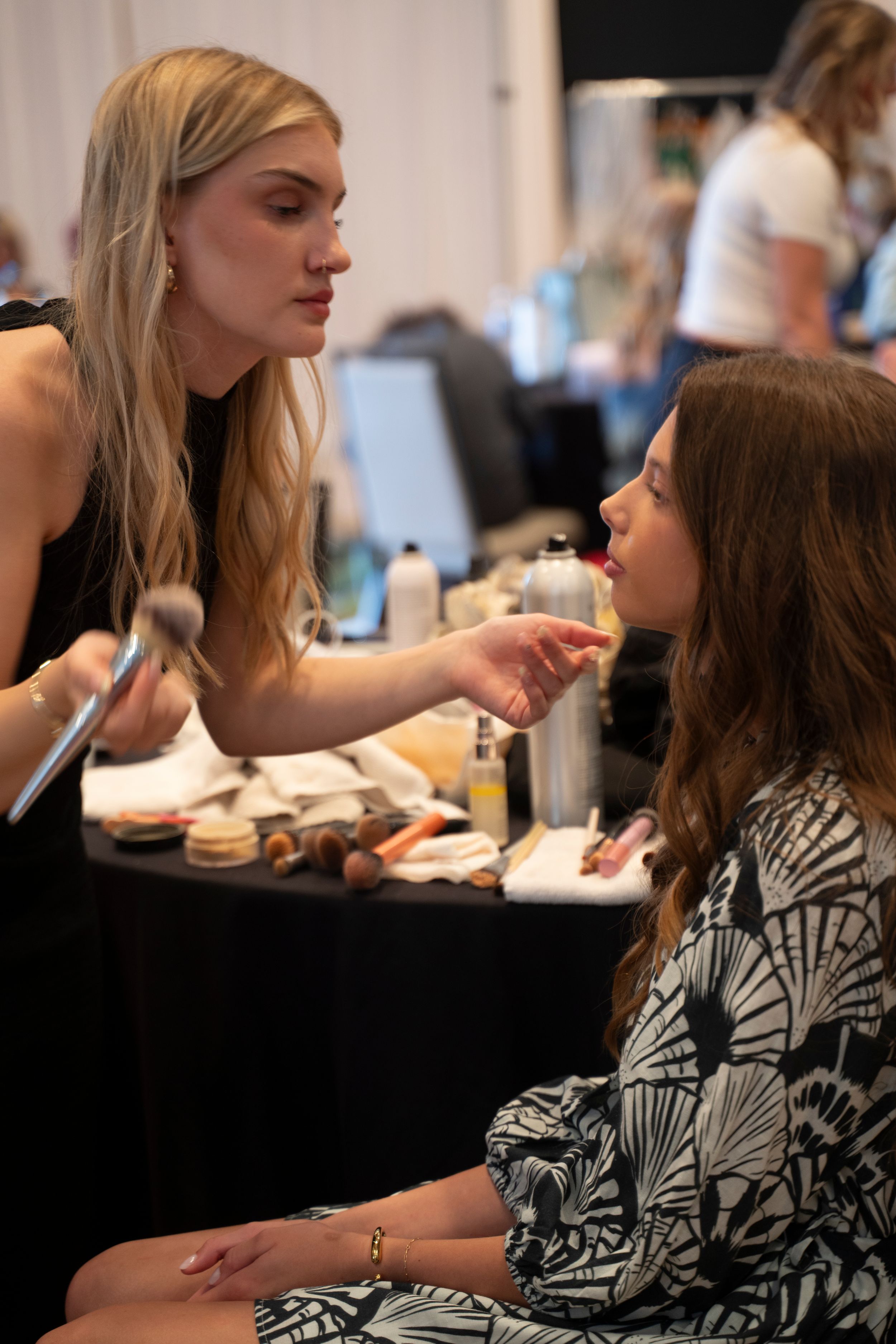 Women getting makeup applied behind the scenes at the Azalea Spring fashion Show 2026 , Holiday Inn Resort, Wrightsville beach