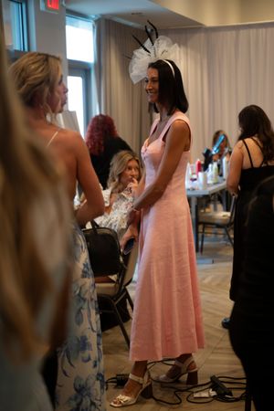 Guests mingling backstage wearing floral dresses and formal attire at the 2026 North Carolina Azalea Festival Spring Fashion Show