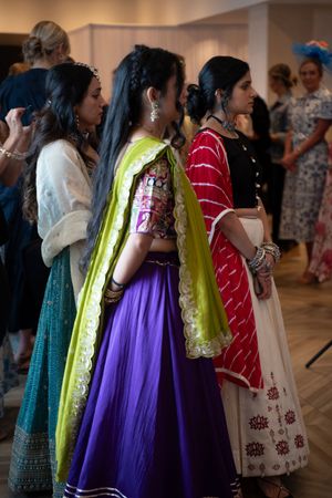 A line of Guest in vibrant formal dresses stand together during the Azelea fashion show 2026