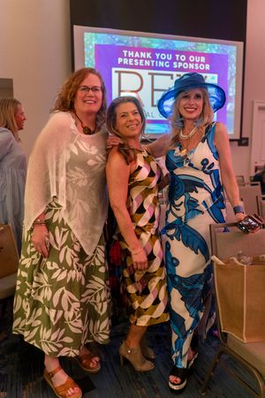 Guest posing together wearing tropical print dresses at the2026 North Carolina Azalea Festival Spring Fashion Show