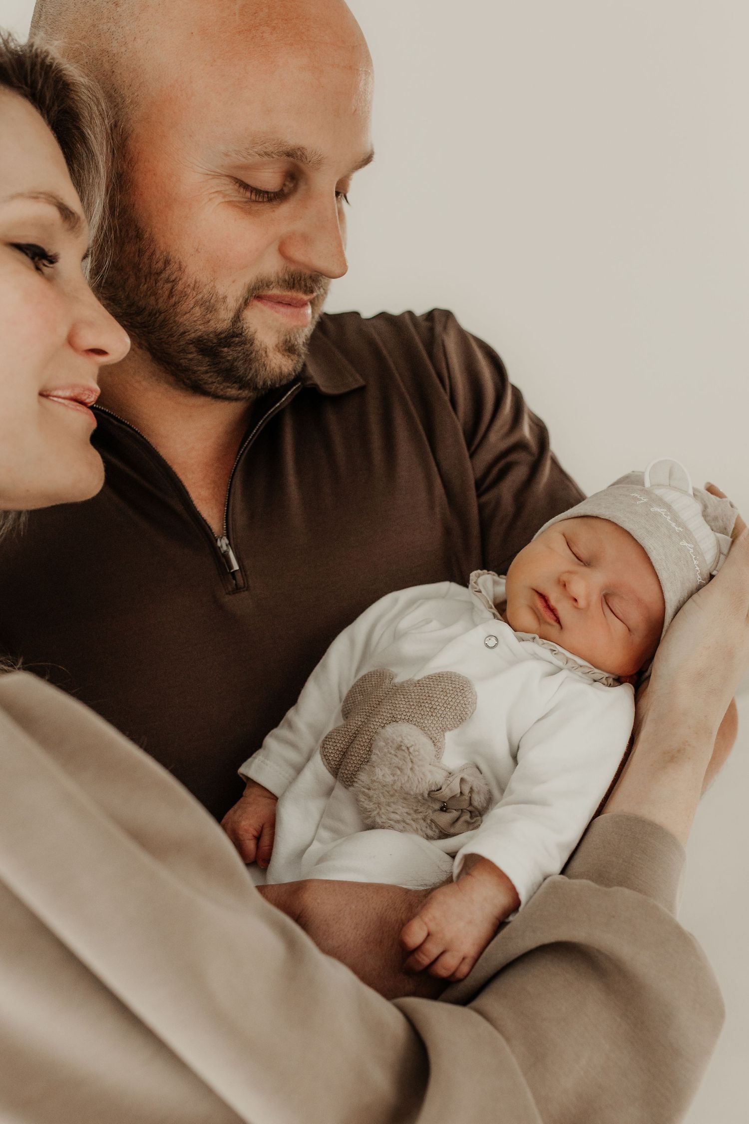 ouders samen met pasgeboren baby intiem moment tijdens newborn shoot
