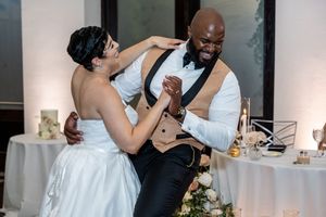 Wedding couple shares a romantic moment during their first dance at an elegant indoor reception venue.