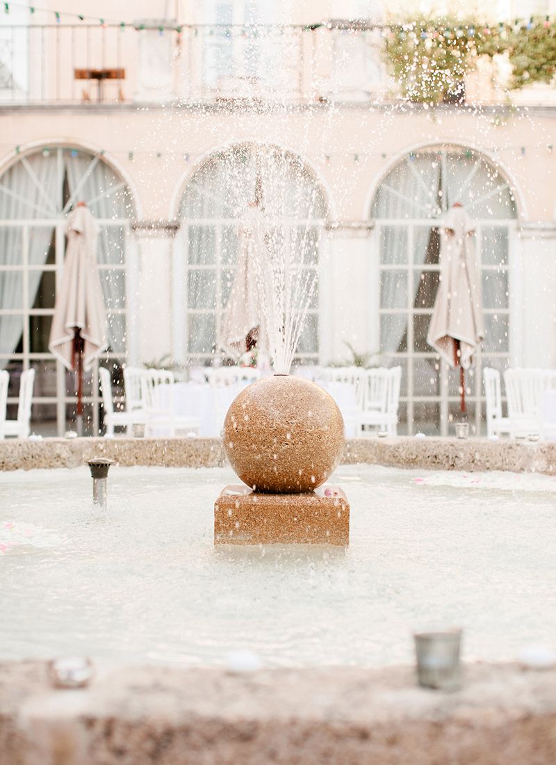 French chateau wedding venue with elegant courtyard, water feature and classic French architecture in a refined destination setting
