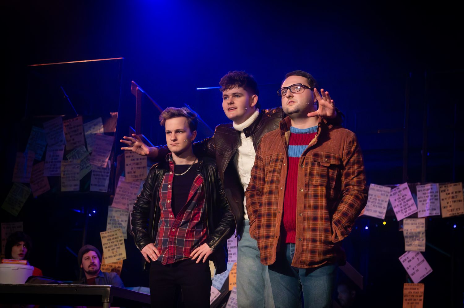 Three young male actors performing on stage in a theatrical production under dramatic lighting. Theatre photography by K Lewis Photography.