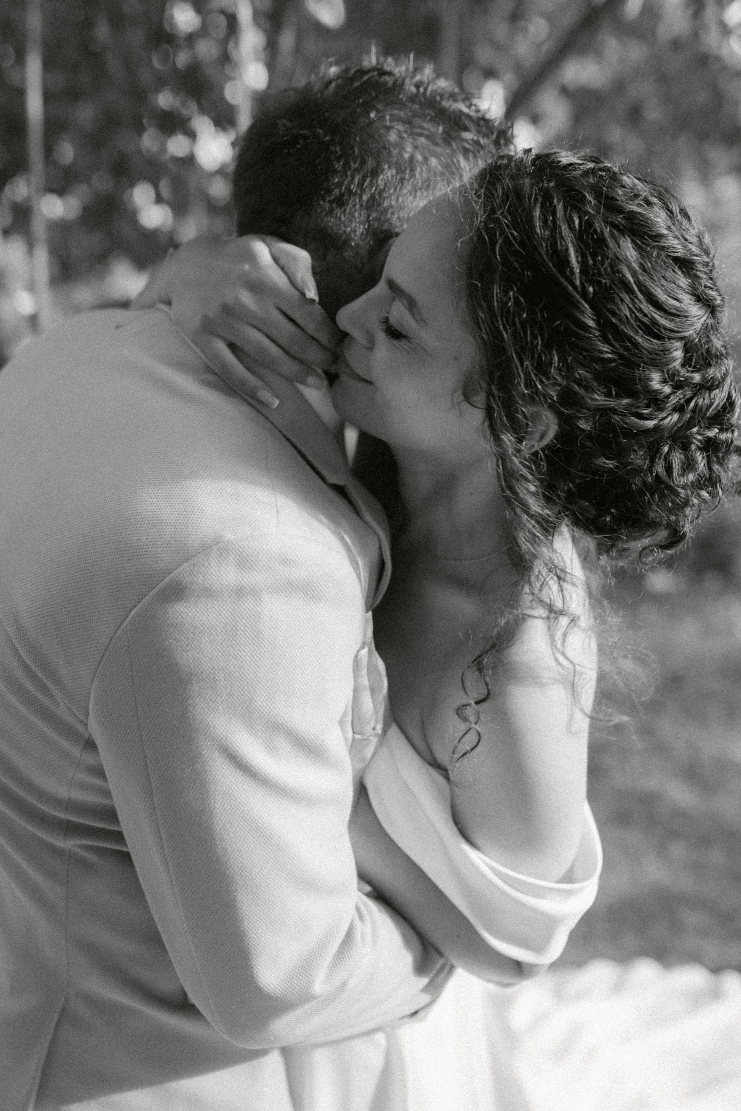 Black and white photo series showing a romantic couple embracing and kissing in an outdoor setting.