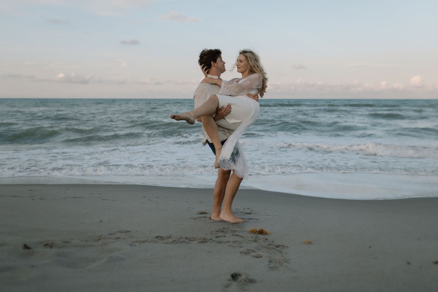 Romantic couples engagement session at sunset on Melbourne Beach, Florida at sunset.
