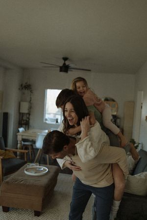 A playful sequence showing people laughing and tumbling on a couch in a bright living room.