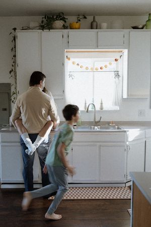Sequence of images showing playful dance movements in a bright white kitchen with windows.