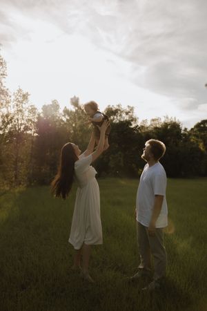 Two people dance and twirl playfully in a sunlit meadow at golden hour.