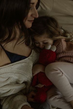 A close-up view of cozy knit sweaters in cream and burgundy colors showing soft textural details.