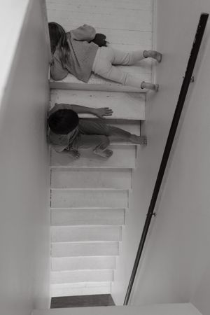 Aerial view sequence showing people lying on white stairs in various positions.