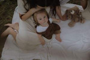 A series of intimate family photos showing tender moments between parents and children on white bedding.