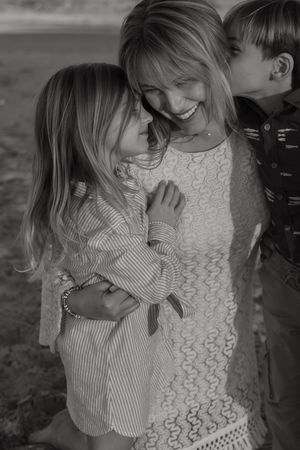 A heartwarming black and white portrait of a family sharing a joyful moment together outdoors.