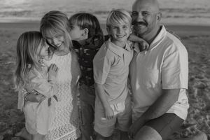 A black and white collage of intimate family moments showing affection and laughter on an outdoor photo shoot.