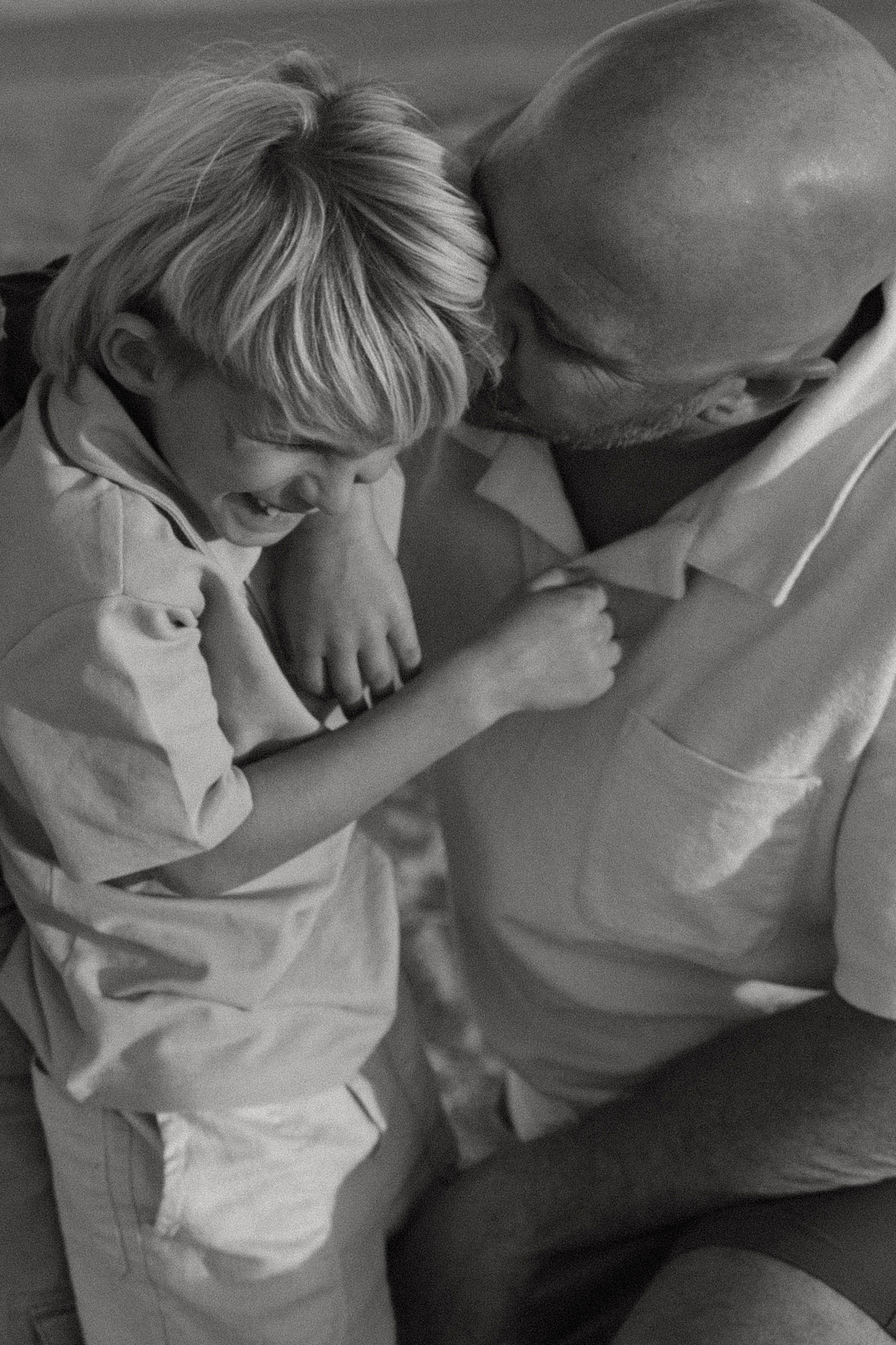 A sequence of black and white photos showing a parent and child sharing an intimate moment of comfort and connection.