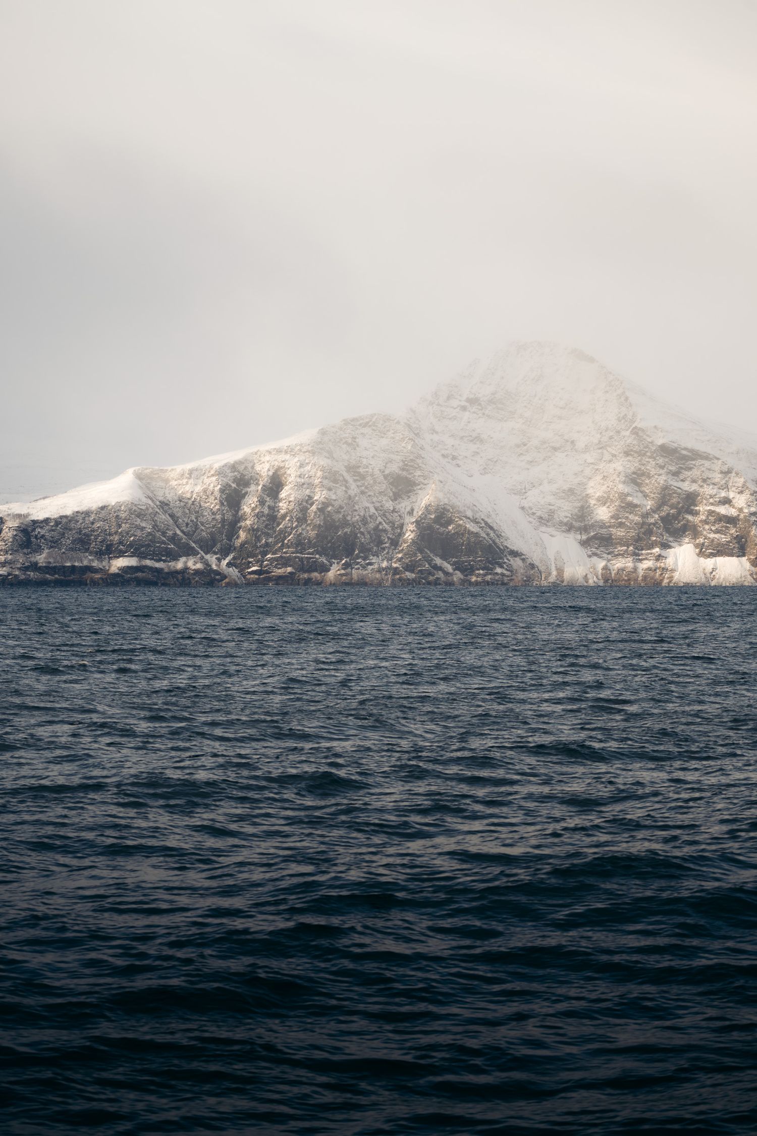 Sommet enneigé au bord d'un fjord en Norvège près de Tromsø